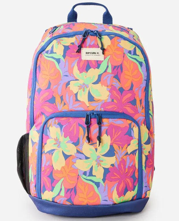 A multicolored floral print Rip Curl women's backpack with a front pocket and adjustable straps.