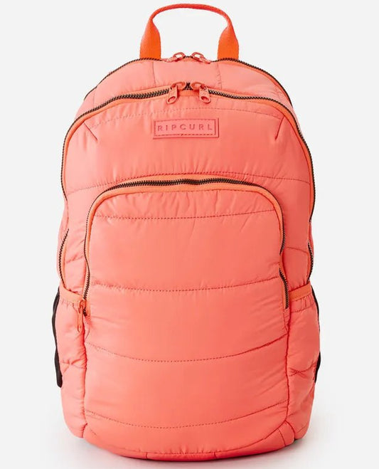A coral-colored Rip Curl women's ozone quilted 30L backpack with front pocket and visible brand logo.