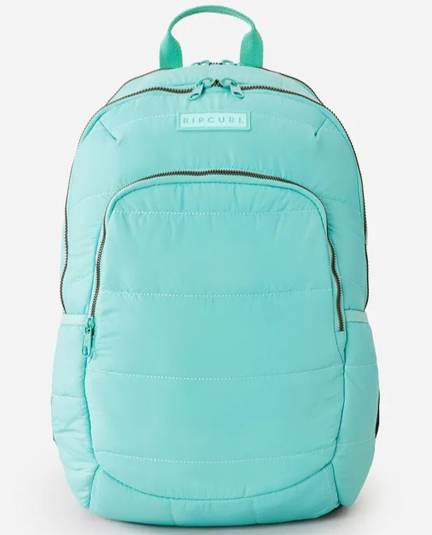 A teal Rip Curl Women's Ozone Quilted 30L Backpack with a front zipper pocket and adjustable straps.